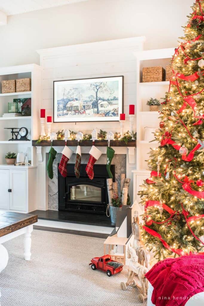 Holiday family room with vintage toys, red accents, and a fireplace hung with stockings