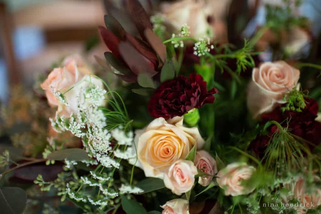 An elegant bouquet of roses and greenery arranged for a fall tablescape.