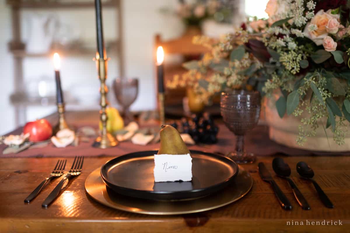 An elegant black plate with a pear on it.