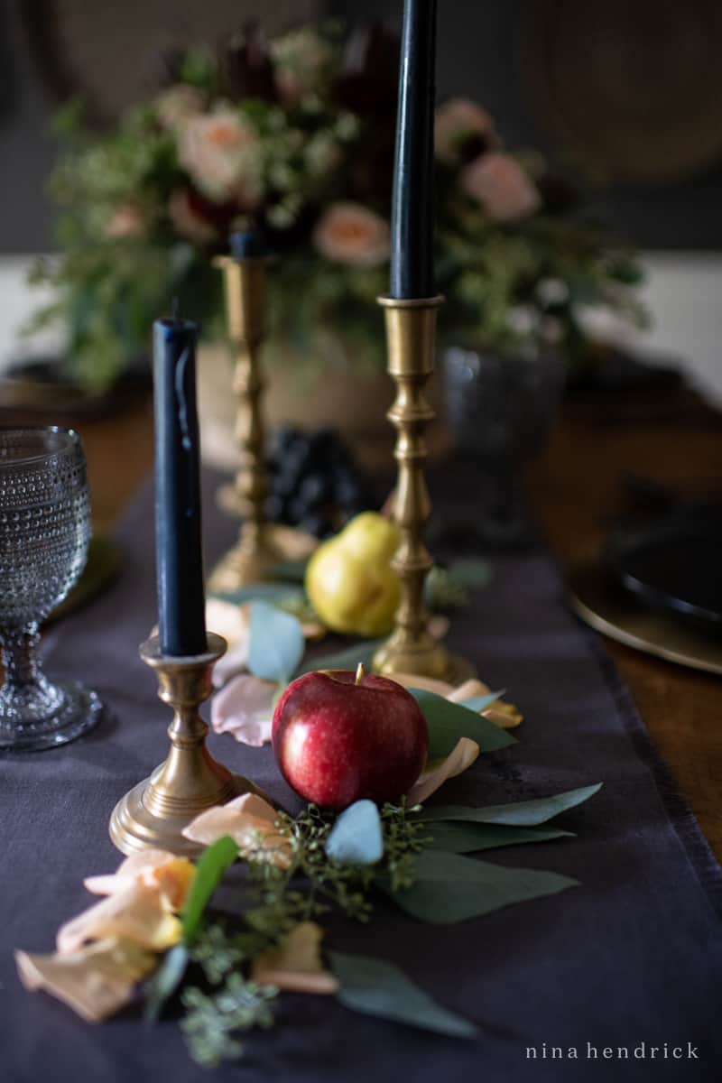 An elegant fall tablescape adorned with candles and apples.