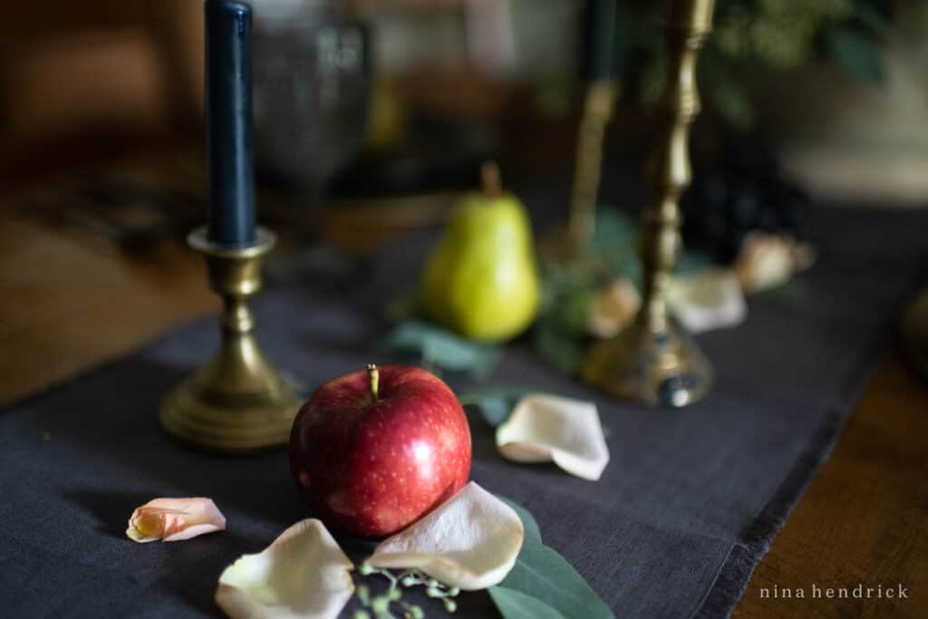 An elegant fall tablescape featuring an apple and a candle.