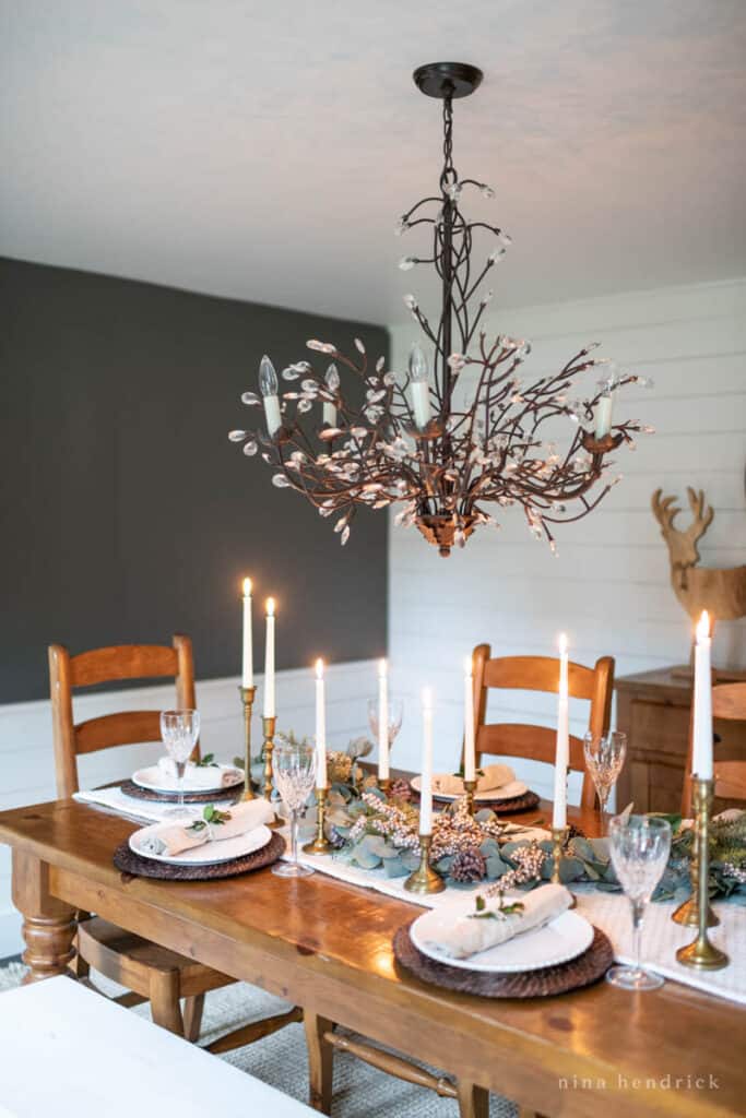 Winter tablescape ideas with brass candlesticks and a wood table