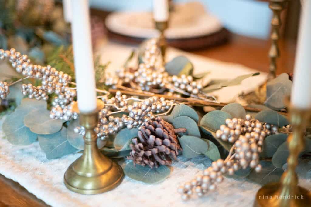 evergreen centerpiece with gold berries and pinecone