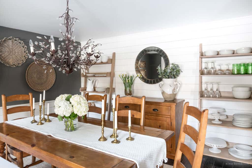 Dining room with wood table and dishes organized on the shelves for entertaining.