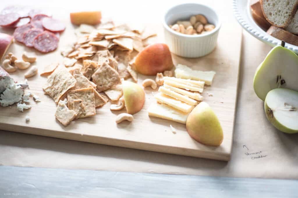 Charcuterie board with cheese, crackers, fruit and nuts.