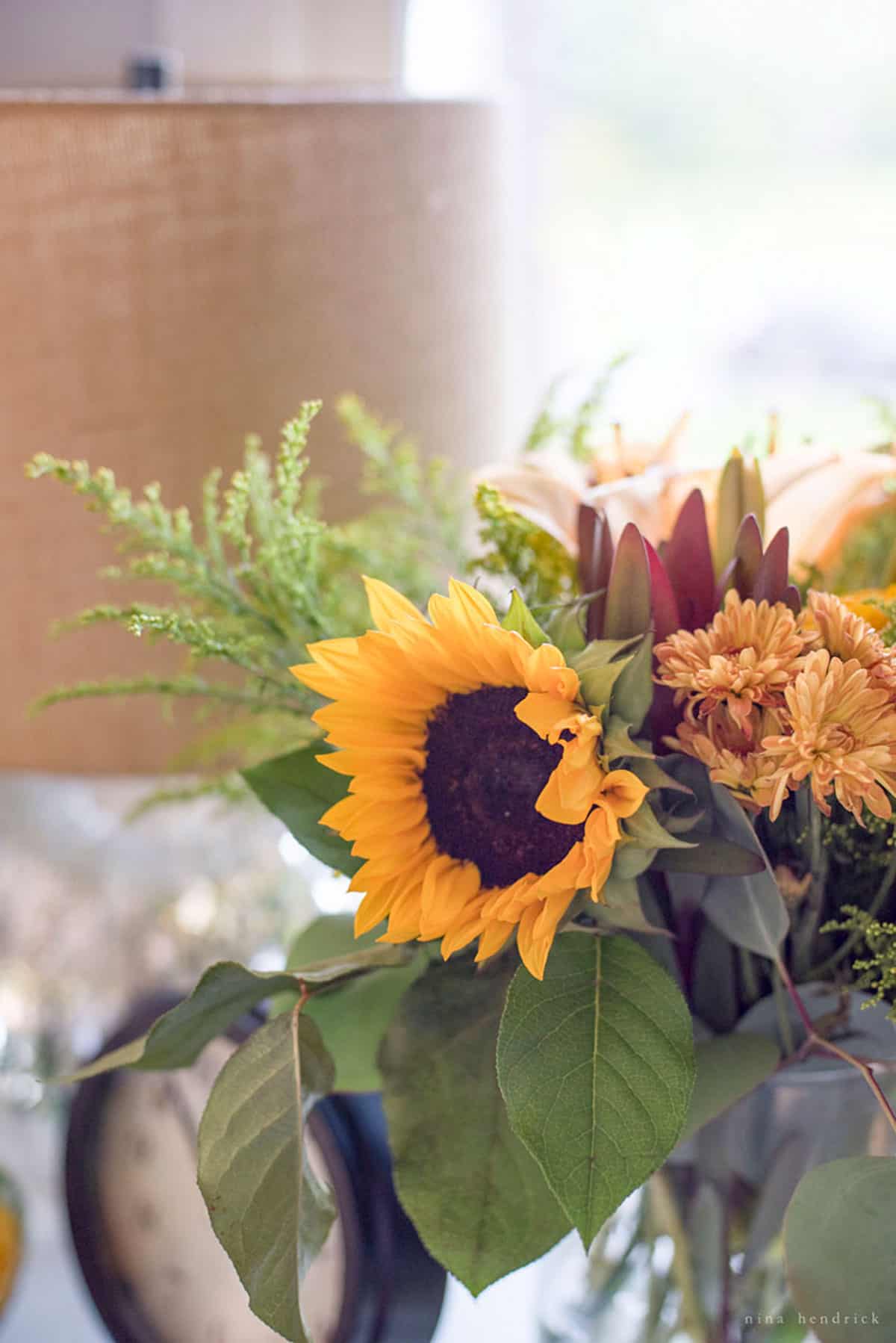 A table adorned with a vase of sunflowers for fall.