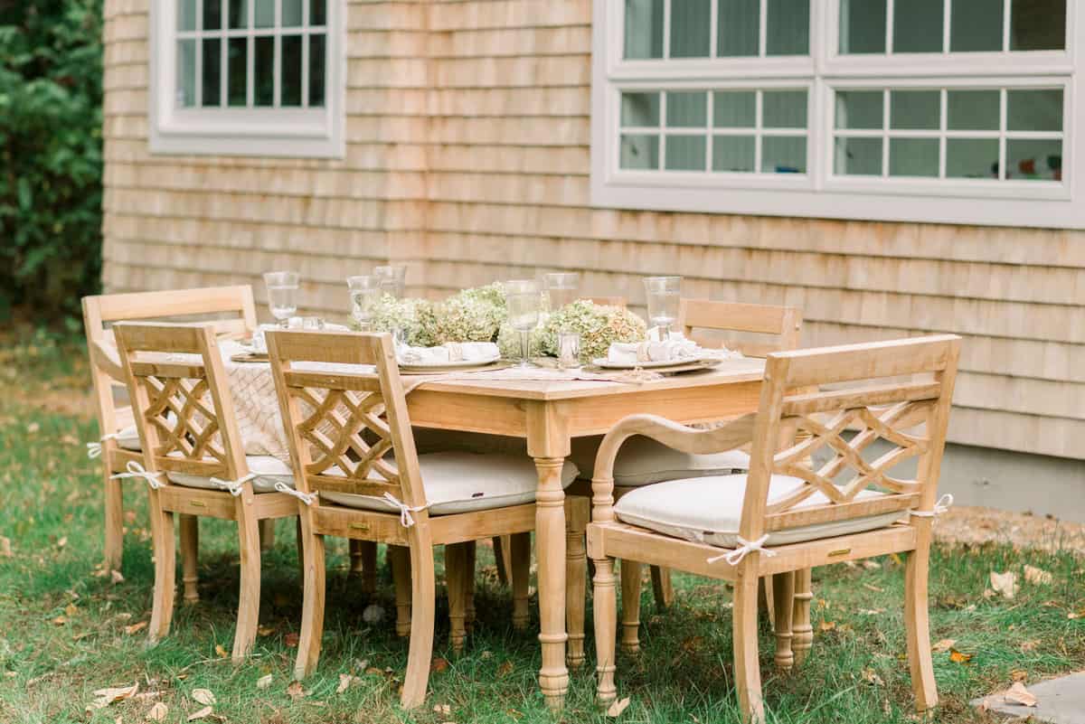 A wooden table and chairs in a backyard.