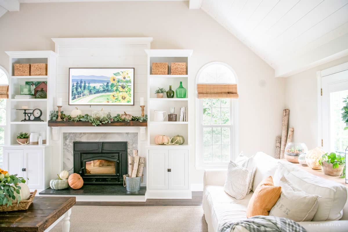 A fall home tour featuring a living room with white furniture and a fireplace.