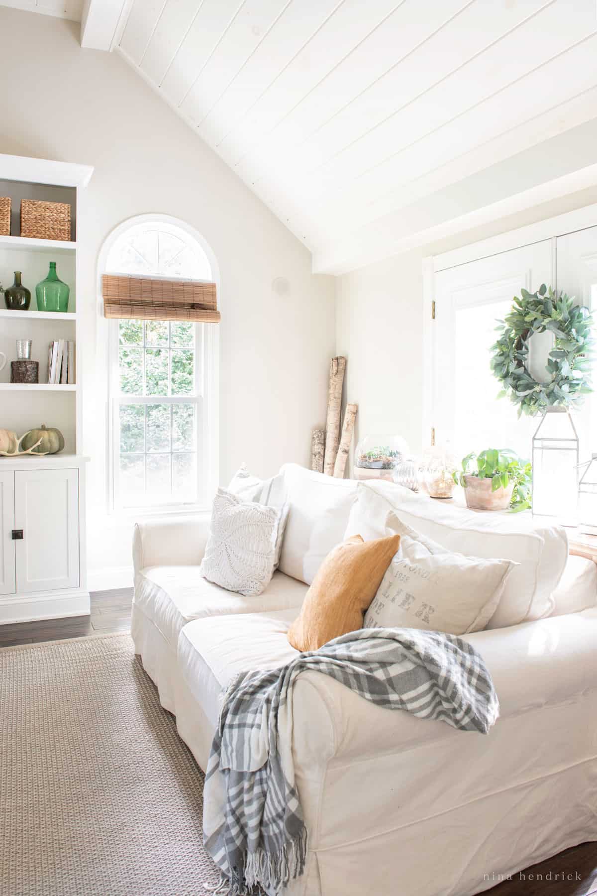 A white couch in an autumn living room.