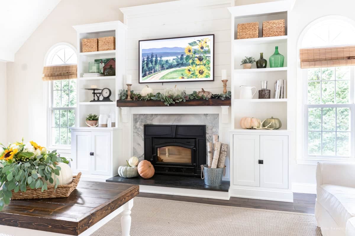 A cozy living room showcasing a fireplace and a tv above it for the fall home tour.