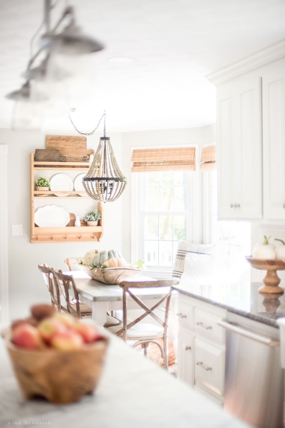 A white kitchen with a wooden table and chairs.