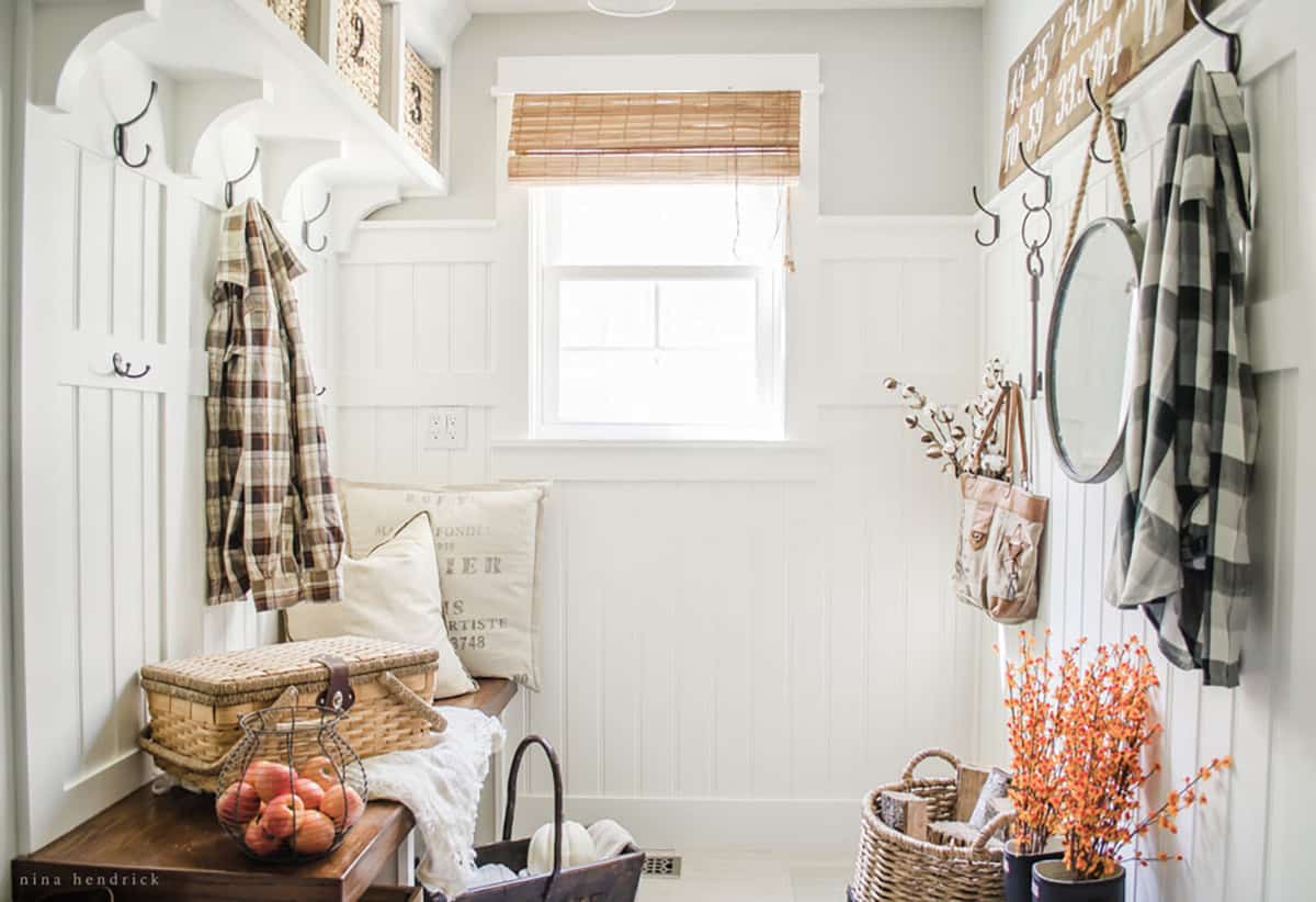 A fall home tour showcasing a white entryway with fall decor and a bench.