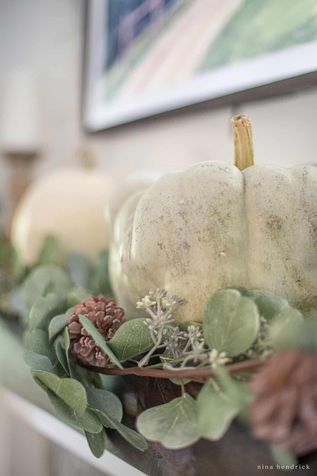 Fall home tour featuring a mantel adorned with white pumpkins and eucalyptus leaves.