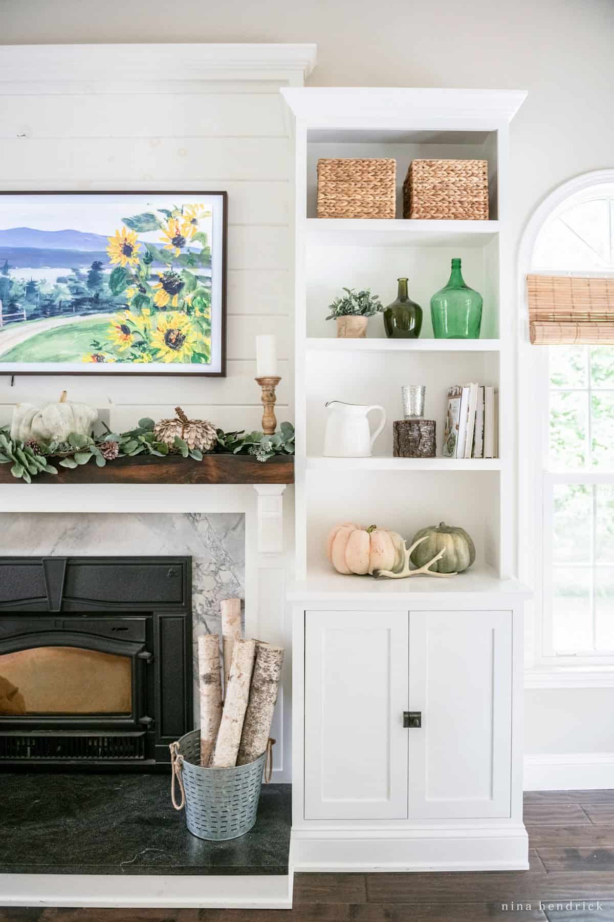 A cozy living room with a white fireplace and bookshelves on a fall home tour.