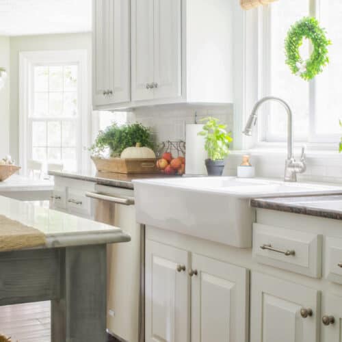 A white kitchen with wood floors and a sink.