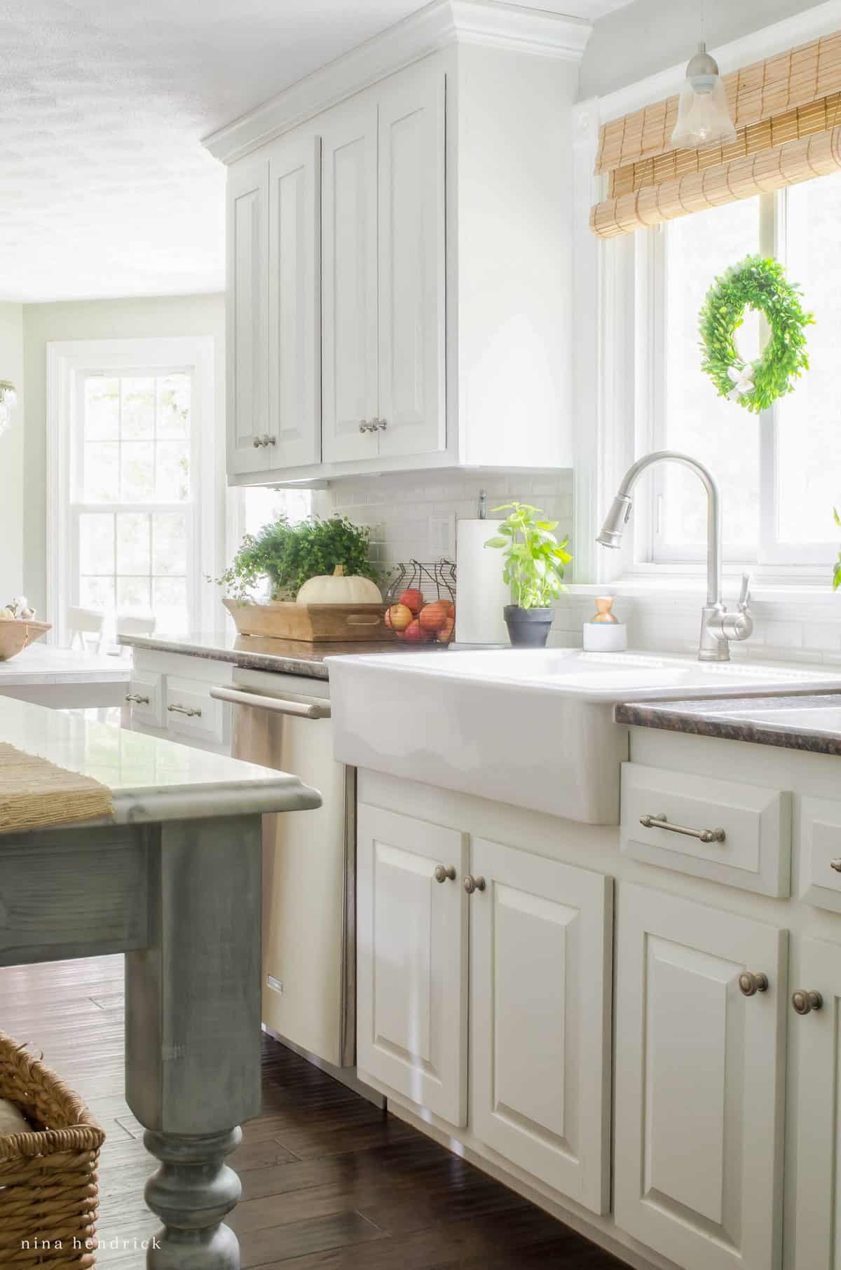 A white kitchen with wood floors and a sink.