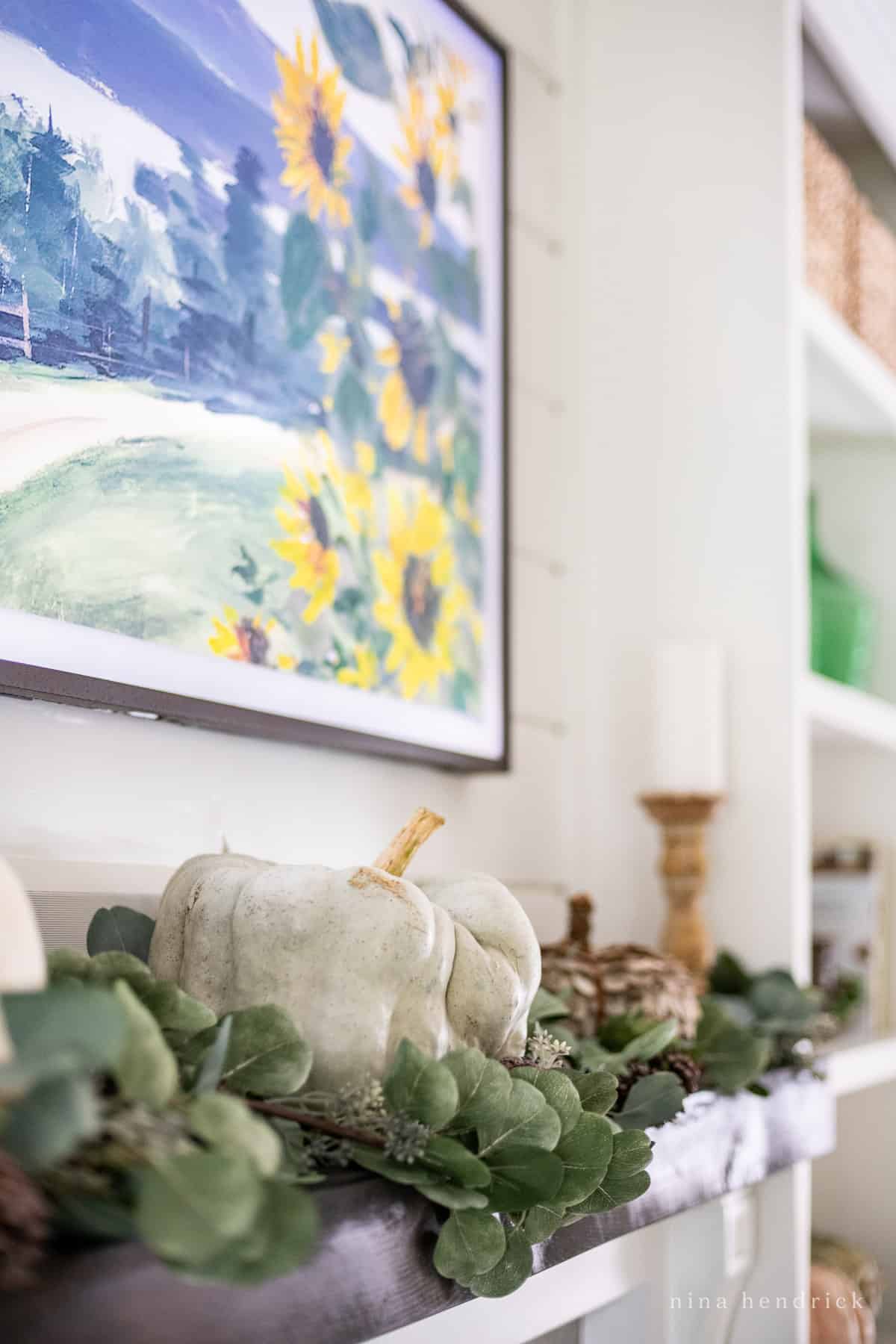 Pumpkins and greenery on a fireplace surround.