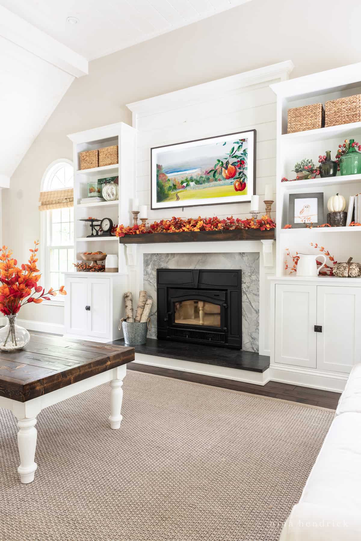 Fall Mantel Decor Ideas in a living room with white built-ins and colorful autumn leaves decorations. 