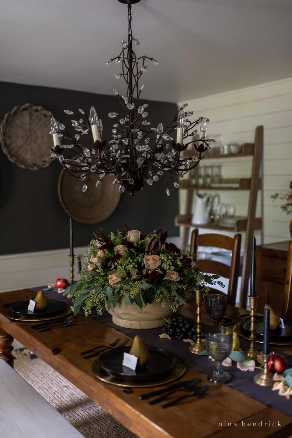 A black and white moody dining room with a chandelier.