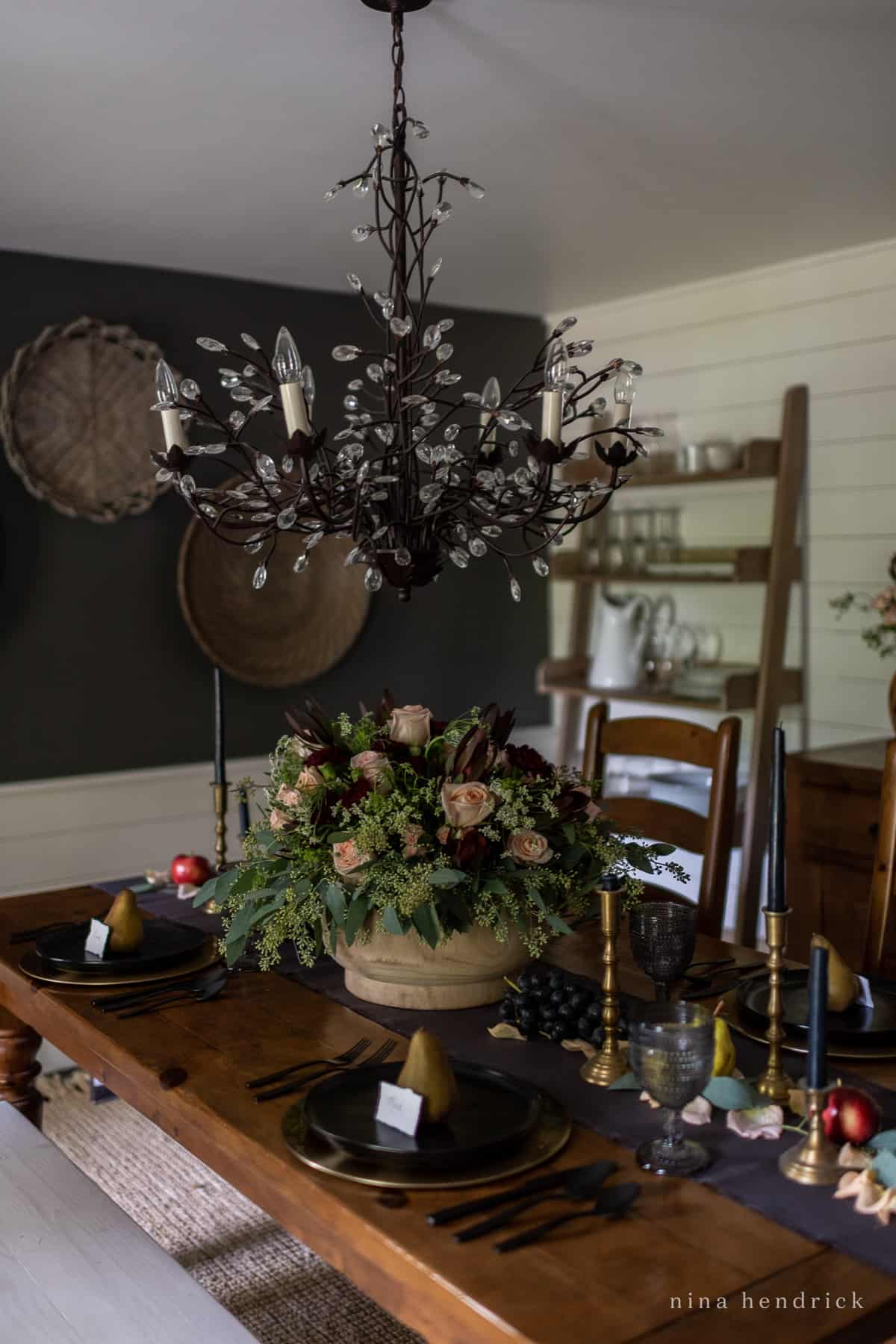 A black and white moody dining room with a chandelier.