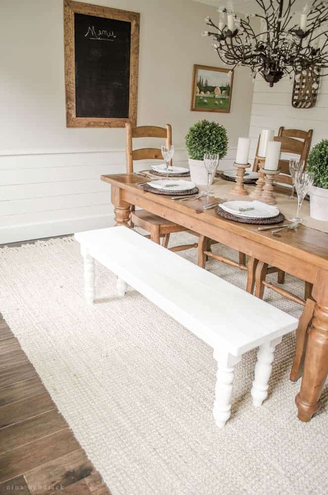 Rustic dining room with a wood farmhouse table and white bench