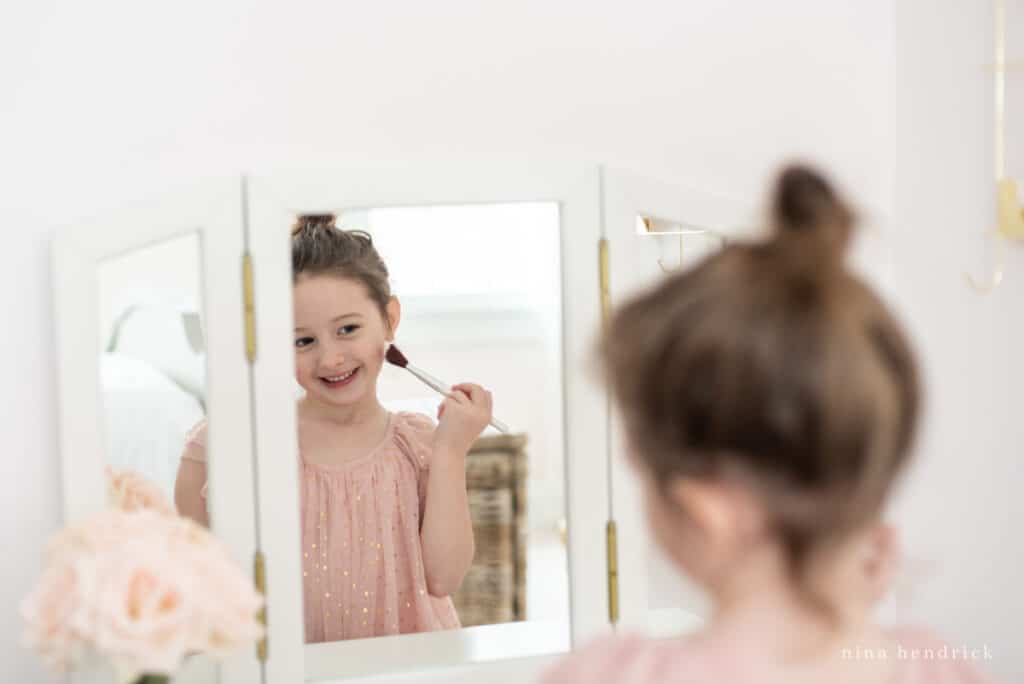 Little girl looking in vanity mirror