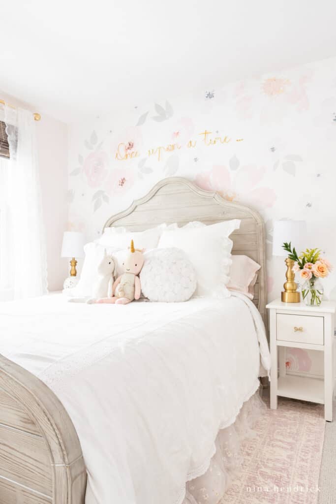 Floral girl room makeover with unicorn stuffed animals and graywash bed.