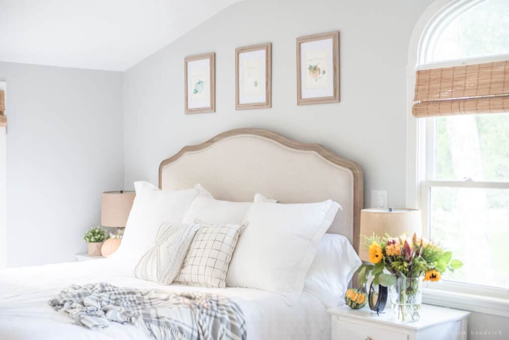 A bedroom with a white bed and white dresser.