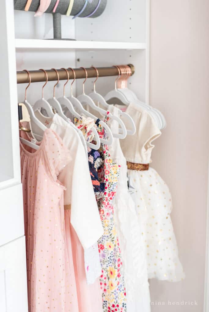 girl organized closet makeover with velvet hangers and pretty princess dresses