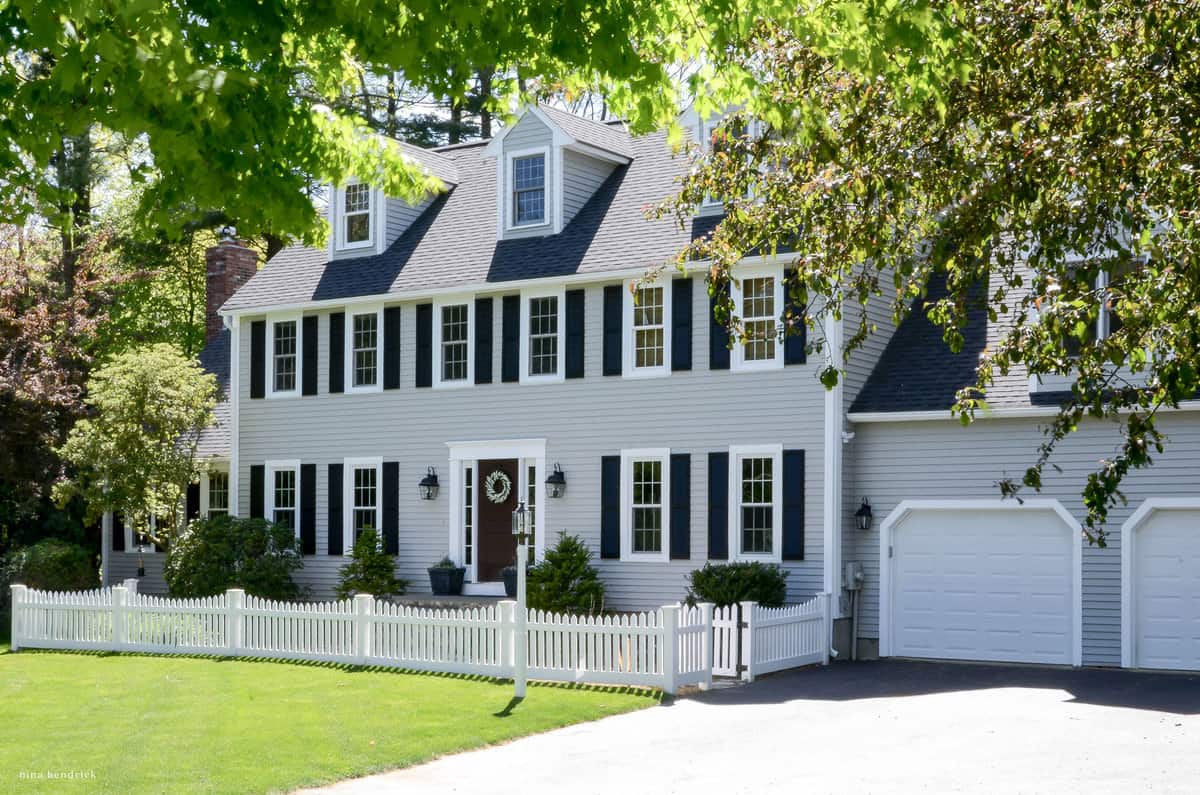 A home painted Benjamin Moore gray Huskie with a white picket fence.