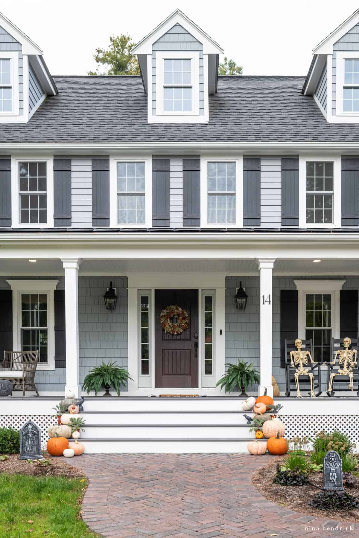 A front porch decorated with pumpkins and a porch swing, perfect for Halloween decorating ideas.
