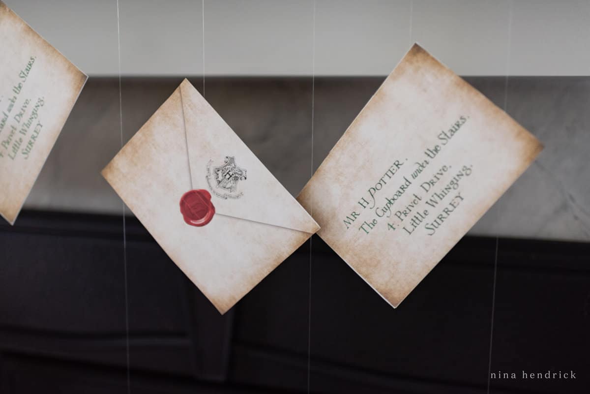 Hogwarts acceptance letter invitations hanging from a mantle.