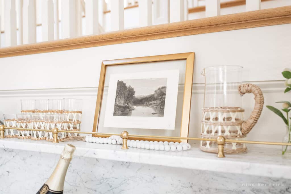 Home bar decor ideas with a gold frame and rattan glassware