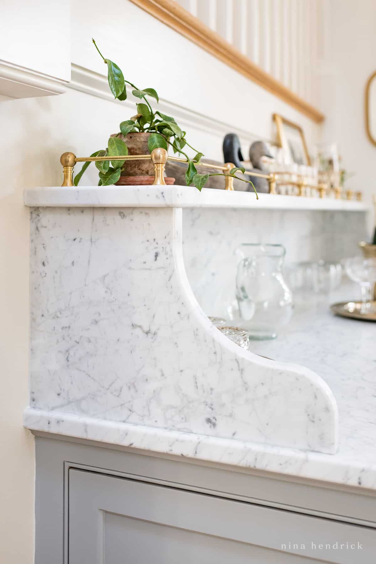 Carrara marble countertop with corbels, shelf, and brass gallery rail