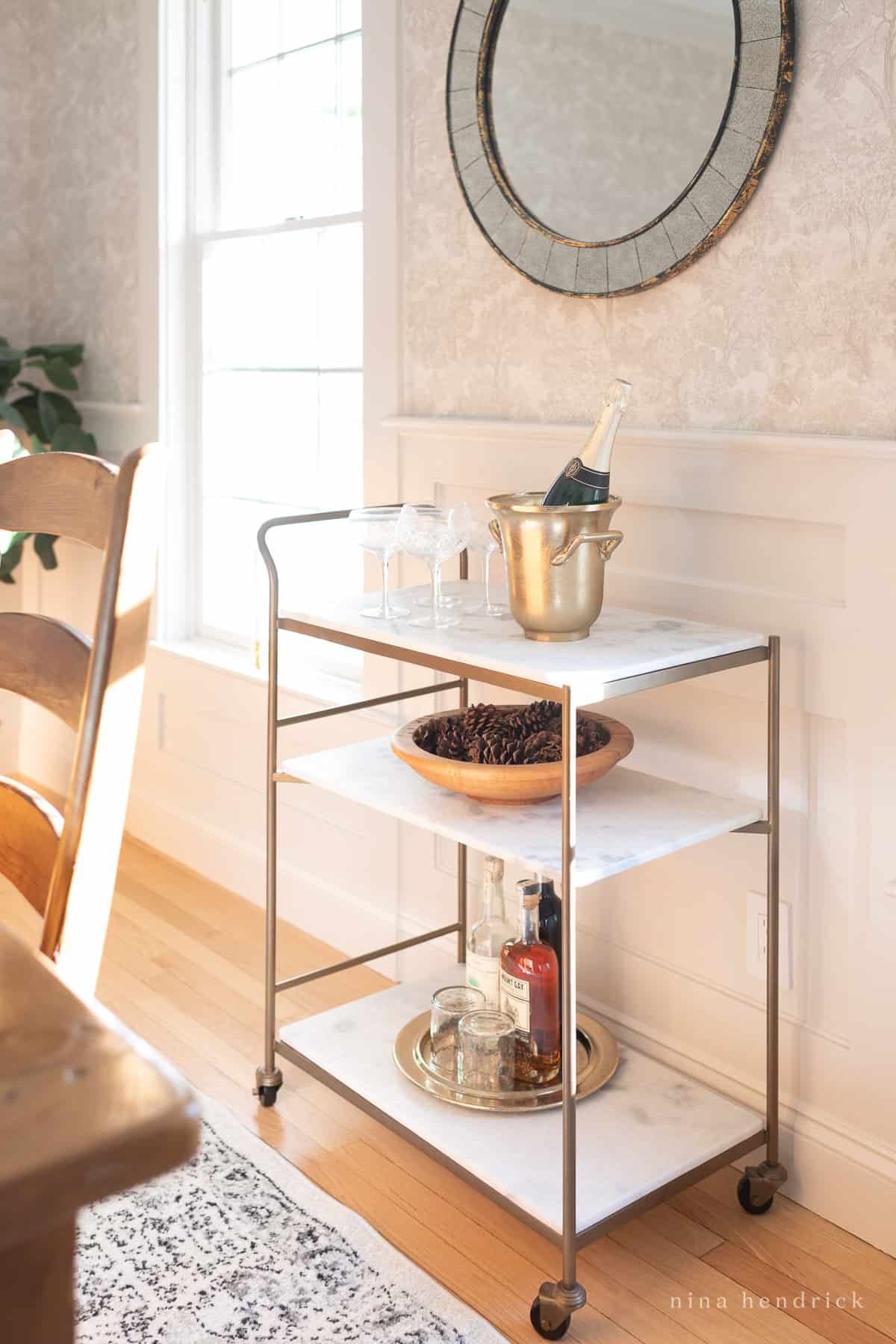 Brass and marble bar cart in sunny dining room