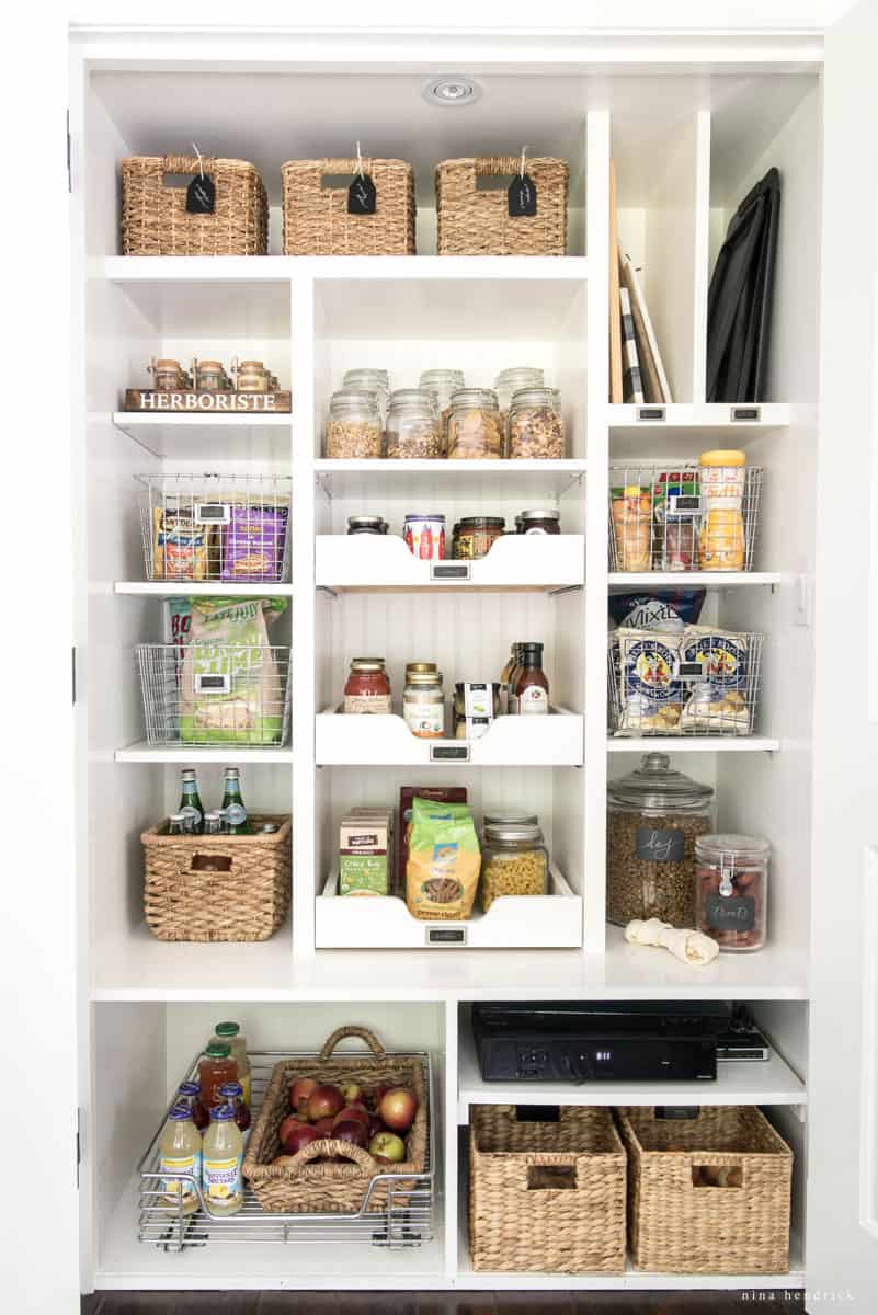 Organized pantry with white shelves and slide-out drawers