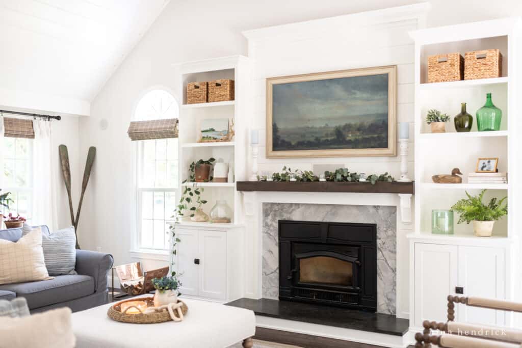 Family room with fireplace and white built-ins with a large painting and cozy furniture