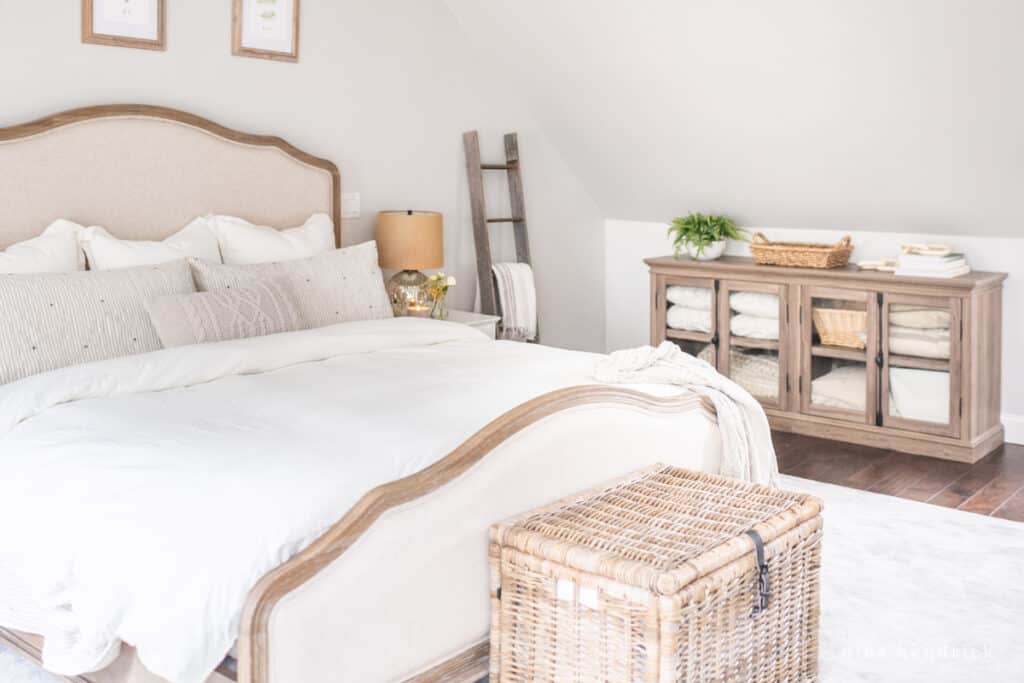 Bedroom with storage trunk and linen cabinet with organized blankets and pillows.