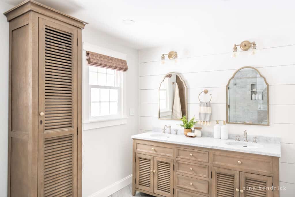 Bathroom with white walls and warm wood storage cabinets.