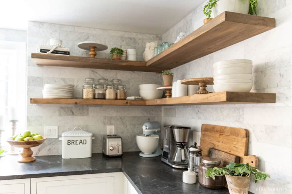 Floating kitchen shelves with glass jars and a bread box for storage to keep your kitchen organized