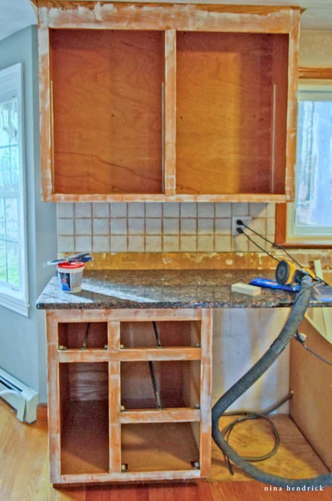 How to Paint Oak Cabinets Tutorial: Fill in grain, damaged areas, and old holes on the outside of cabinet boxes with Drydex and putty knife