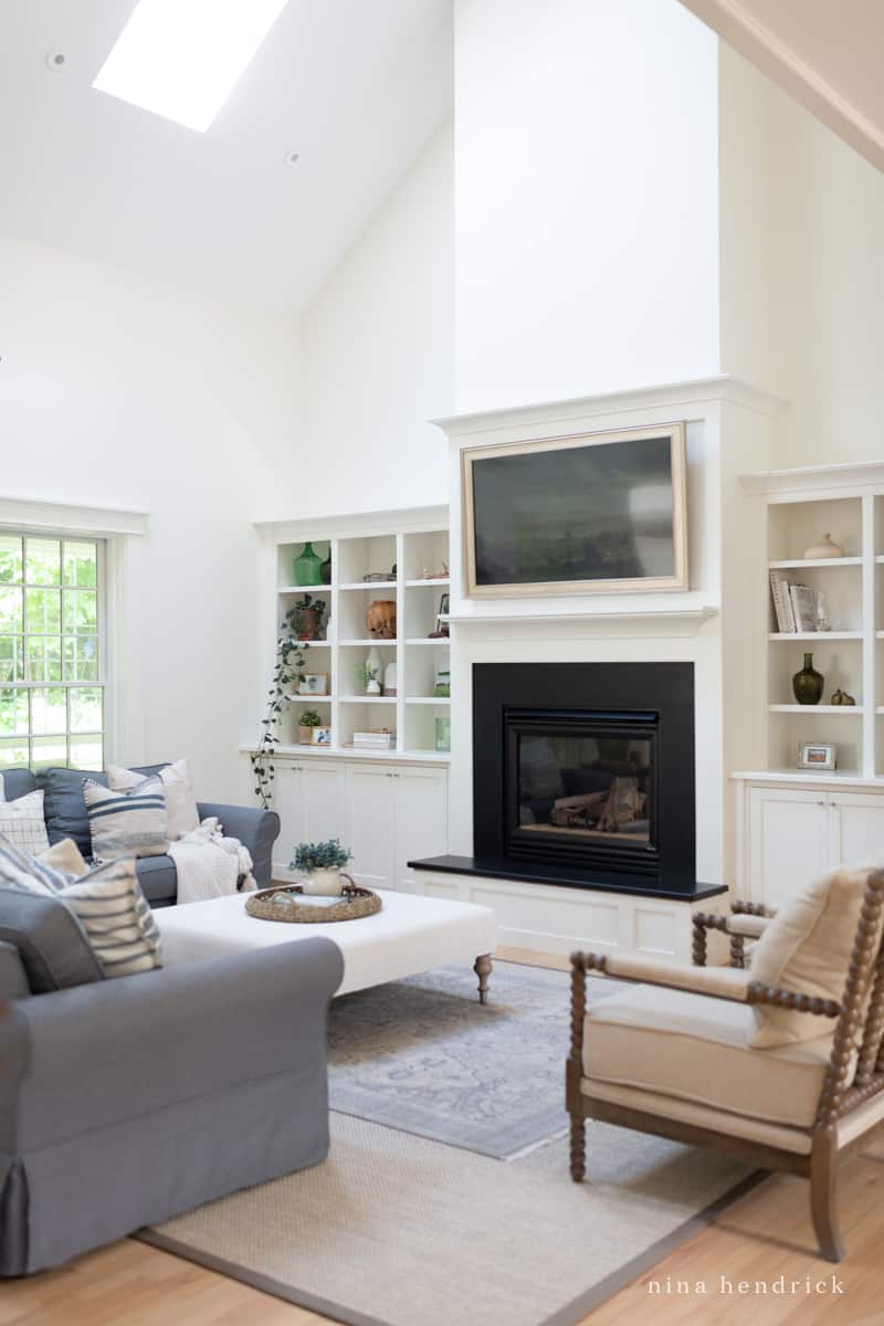 Open concept living room with furniture arranged around a fireplace focal point