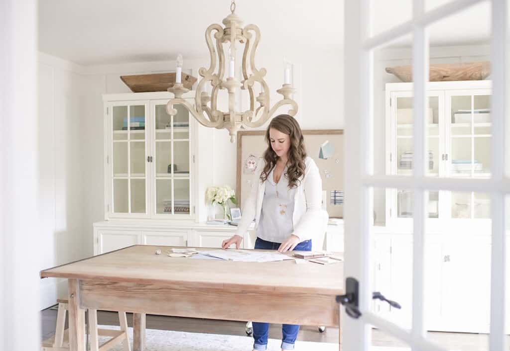 Nina Hendrick in office looking at design plans and choosing paint colors