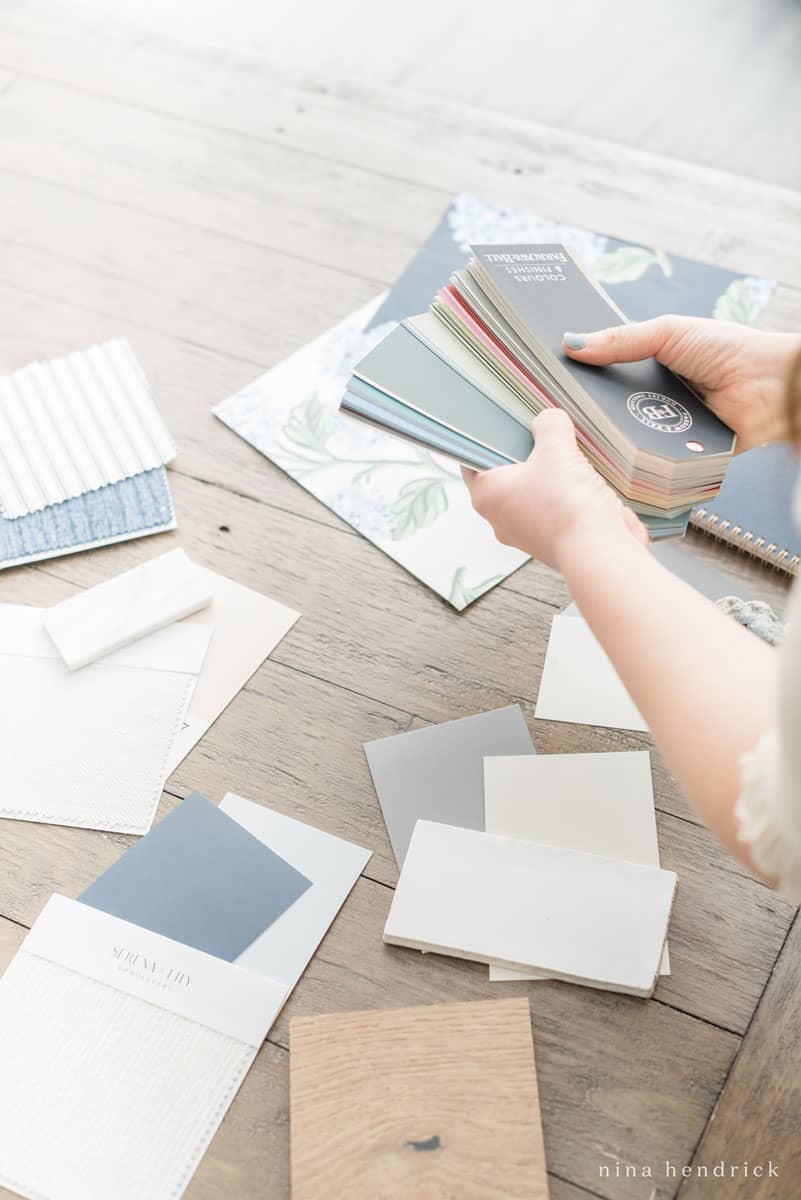 Woman with paint fan deck to choose paint colors