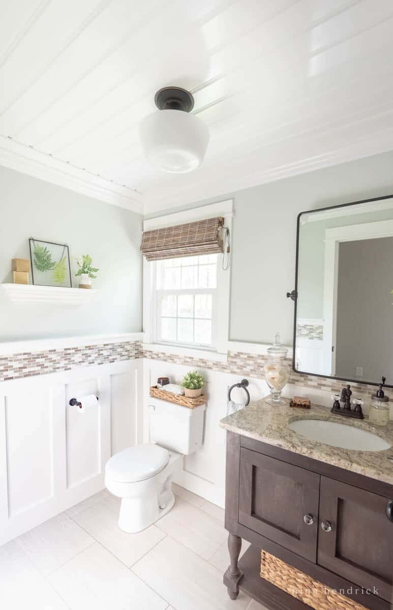 Powder bathroom with dark wood vanity and a tile border