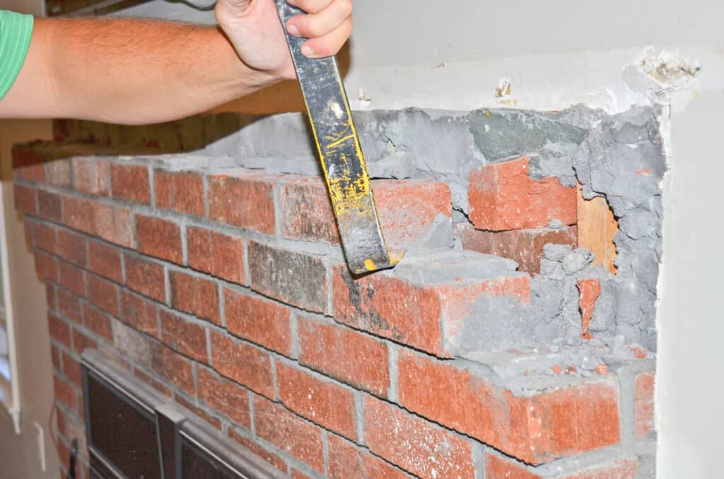 Demoing a brick fireplace and removing the top courses to wrap it in wood.