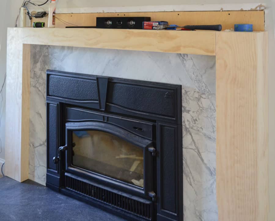 Brick fireplace covered with wood surround awaiting trim