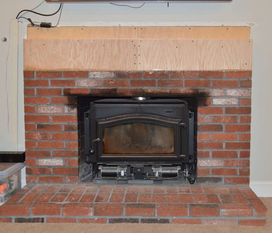 brick fireplace with wood building out the top courses in anticipation of stone.