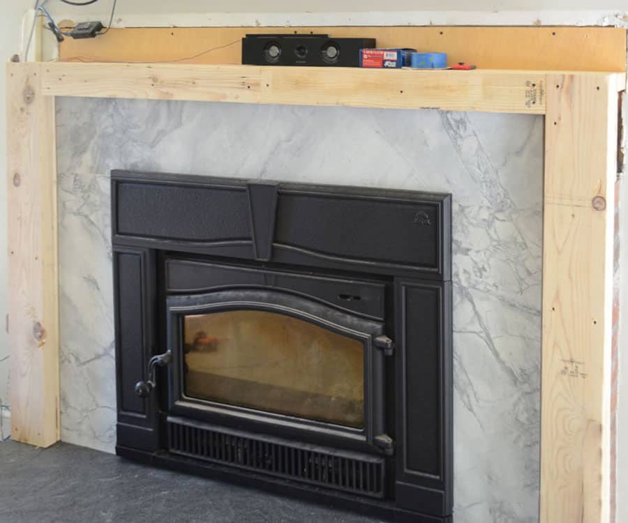 Fireplace covered in superwhite quartz stone and wood framing