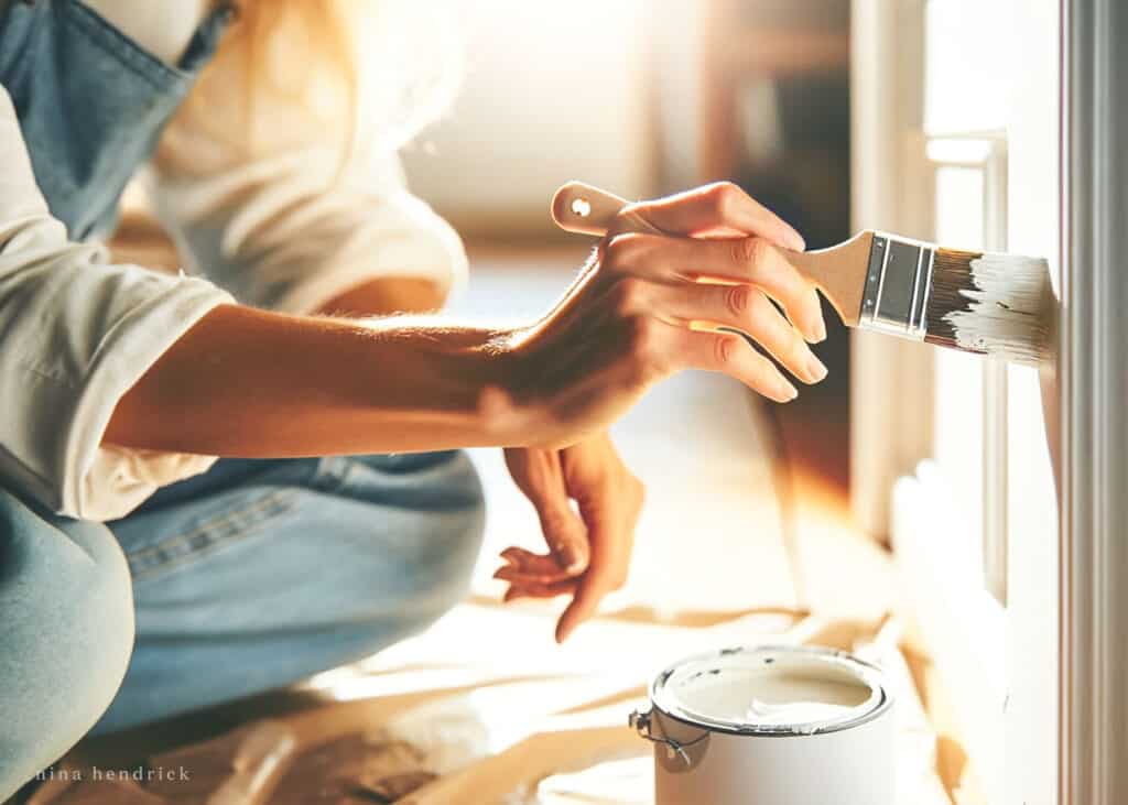 A woman painting a wall as part of her room renovation project.